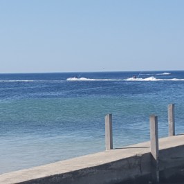 Jet skis off in the distance as seen from the beach